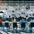 Modernes Büro mit jungem Marketing-Team, das konzentriert an Computern mit Podcast-Workflows, Audio-Wellenformen und SEO-Dashboards arbeitet, KI-Visualisierungen im Hintergrund und Whiteboard mit technischen Begriffen.