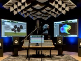 Modernes, immersives Audio-Studio mit Kunstkopf-Mikrofon, Ambisonic-Mikrofonen und mehreren Monitoren mit DAW-Software, umgeben von Absorbern und Diffusoren.