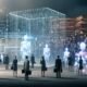 Futuristische Szene mit transparentem Gesetzestext aus digitalen Daten, durchzogen von leuchtenden Algorithmen und KI-Silhouetten, flankiert von Menschen in Anzügen; im Hintergrund verblassende Papierstapel und helle Datenwolken.