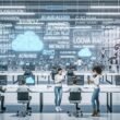 Technisch fortschrittliches Büro mit großen transparenten Bildschirm-Displays, die Video-Workflows und KI-Grafiken zeigen. Junge Professionals arbeiten im Team an digitalen Dashboards, während Roboterarme Hardware bedienen.