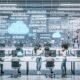 Technisch fortschrittliches Büro mit großen transparenten Bildschirm-Displays, die Video-Workflows und KI-Grafiken zeigen. Junge Professionals arbeiten im Team an digitalen Dashboards, während Roboterarme Hardware bedienen.