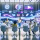 Futuristisches Büro mit digitalem Marketingteam, das KI-Tools für automatisierte Videobearbeitung, Untertitel und Content-Distribution nutzt. Im Hintergrund sind Vergleiche führender Videoplattformen sichtbar.