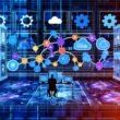 Minimalistische Illustration eines modernen Marketingbüros mit Person vor mehreren Bildschirmen, die Marketing-Tools und fließende Datenströme zeigen. Im Hintergrund Cloud-Symbole, Serverracks und Monitoring-Icons in blauen Tönen mit Neon-Orange und Lila.
