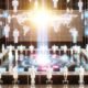 Futuristischer Raum mit Menschen an Holo-Screens, die digitale Abstimmungen durchführen, umgeben von Blockchain-Visualisierungen und einem leuchtenden Wahldashboard.
