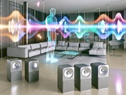 Futuristisches Wohnzimmer mit neutralen Möbeln, verteilten Sonos-Speakern und sichtbaren bunten Klangwellen, die sich an eine gehende Person mit Smartphone anpassen. Digitale AR-Elemente schweben an den Wänden.