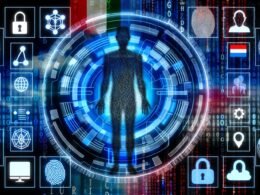 Futuristische Collage einer menschlichen Silhouette aus digitalen Daten, Avataren, Logins, biometrischen Mustern, Blockchain- und Cloud-Icons, Fingerabdruck, Passwörtern und Länder-Flaggen vor leuchtenden Codezeilen und Protokollsymbolen.