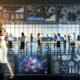 Modernes Büro mit diversen Teams, die an digitalen Dashboards und Touchscreens arbeiten, Datenströme und Diagramme analysieren und smarte Entscheidungen treffen.