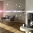 Modernes Wohnzimmer mit Sonos-Lautsprecher, grafischen Audio-Wellen und Kontextdaten wie Kaffeetasse, Uhr und Nutzer-Silhouette, was die Integration smarter Audio-Technologie im Alltag zeigt.