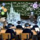 Bild einer futuristischen Schulumgebung mit Lernenden, die VR-Brillen und AR-Headsets tragen, umgeben von leuchtenden 3D-Hologrammen und unterstützt durch einen digitalen KI-Avatar.