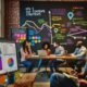 Redaktionsszene mit Content-Stratege vor bunten KPI-Dashboards und Teamarbeit am Whiteboard in einem offenen Büro