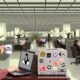Junge Verwaltungsmitarbeiter in einem modernen Büro arbeiten an Laptops mit Linux-Aufklebern, umgeben von klassischen und digitalen Büroelementen, einer hebt eine Kaffeetasse mit 'Digital Souveränität'.