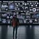 Futuristischer, dunkler Redaktionsraum mit digitalen Dashboards, Medienanalysen und vernetztem Editor vor leuchtendem Schriftzug 'Reichweite ist kein Zufall'.
