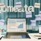 Moderne Computer-Workstation mit Laptop, Redaktionsplan-Notizen, Kaffeetasse und Smartphone mit Newsletter-Analyse; im Hintergrund Post-Its mit Online-Marketing-Begriffen.