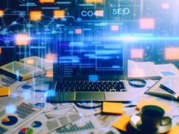 Laptop auf unordentlichem Schreibtisch mit Notizzetteln, Fachbüchern und leuchtenden SEO-Diagrammen, umgeben von holografischen Datenströmen und Internet-Symbolen.