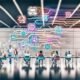 Kreatives Team arbeitet kollaborativ an digitalen Whiteboards im modernen Großraumbüro, umgeben von leuchtenden Grafiken, Datenströmen und Icons für zentrale digitale Tools wie Headless CMS und KI-Systeme.