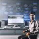 Moderatorner Arbeitsplatz eines Digitalstrategen mit großem Monitor, der eine Website mit Blog-Sektion zeigt, surrounded von SEO-Flussdiagrammen und Datenvisualisierungen.