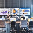 Fokussierte Marketing-Mitarbeiter in urbanem Büro mit digitalen SEO-Dashboards, Whiteboard mit KPIs und Post-its zu zentralen Metriken.