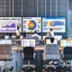 Fokussierte Marketing-Mitarbeiter in urbanem Büro mit digitalen SEO-Dashboards, Whiteboard mit KPIs und Post-its zu zentralen Metriken.