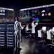 SEO War Room mit großen Bildschirmen voller Statistiken, arbeitenden Spezialisten und modernen Analysetools in urbaner Büro-Atmosphäre
