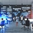 SEO-Experten arbeiten konzentriert in einem modernen Großraumbüro an Monitoren mit technischen Analysen, Website-Audits und Keyword-Daten, umgeben von Whiteboards mit Strategiediagrammen.