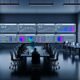 Online-Marketing-Kontrollzentrum mit ultrabreiten Monitoren, farblich akzentuierten Dashboards, KPI-Analysen und diverser Gruppe von Marketers und Data Scientists an Laptops in kühlem Neon-Licht.