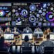 Digitales Performance-Marketing-Team arbeitet fokussiert an Laptops vor großen Monitoren mit KPI-Dashboards, Conversion-Funnels und Echtzeitdaten in einem modernen Büro.