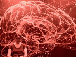 Abstraktes rotes Netzwerk in Form eines Gehirns mit einer Person im Vordergrund, Technologie visualisierend