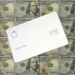 Eine Apple Card liegt auf mehreren Hundert-Dollar-Scheinen und symbolisiert digitale Bezahllösungen im Finanzsektor.