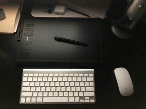 Apple Wireless Keyboard und Magic Mouse auf einem Schreibtisch als modernes Arbeitsplatz-Setup, aufgenommen von Drew Thomas.