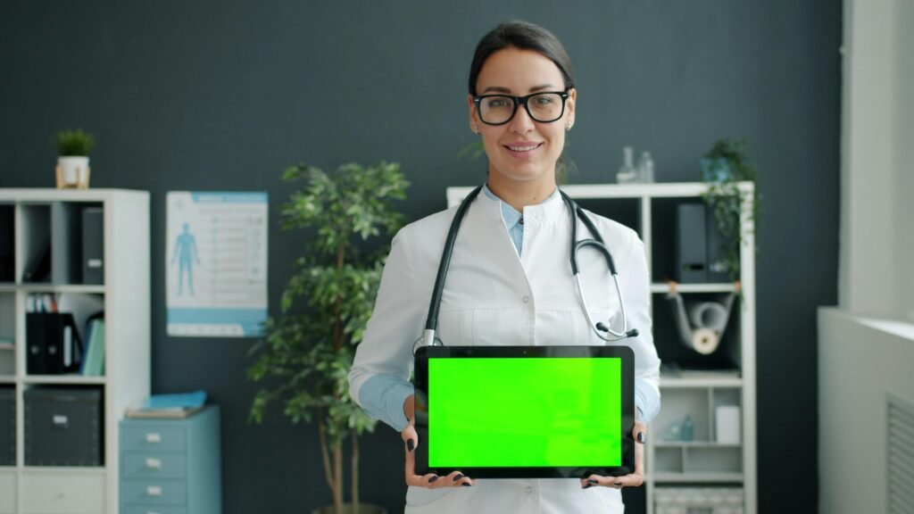 Arzt hält ein Tablet mit grünem Bildschirm, Symbol für moderne digitale Medizin und Technologien im Gesundheitswesen
