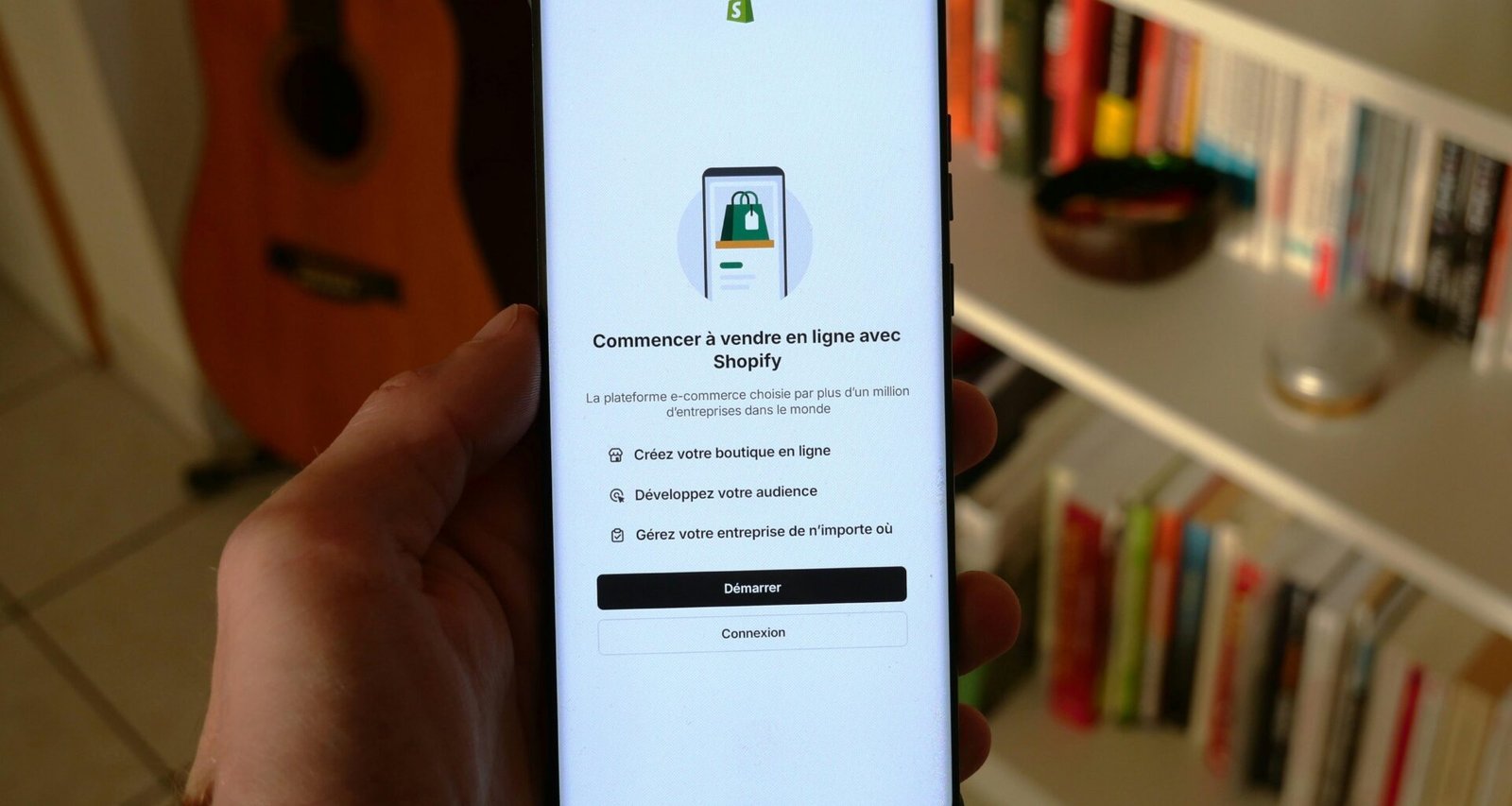 Ein Smartphone präsentiert den Einrichtungsbildschirm der Shopify App, optimal für den Start eines Onlineshops unterwegs.