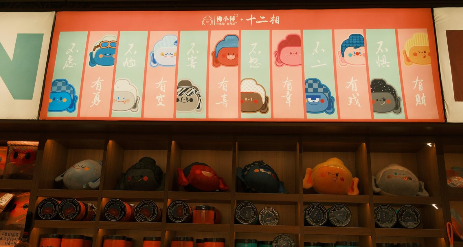 Mehrere Daruma-Puppen und passendes Merchandise werden in einem japanischen Geschäft auf einem Regal nebeneinandergestellt präsentiert.