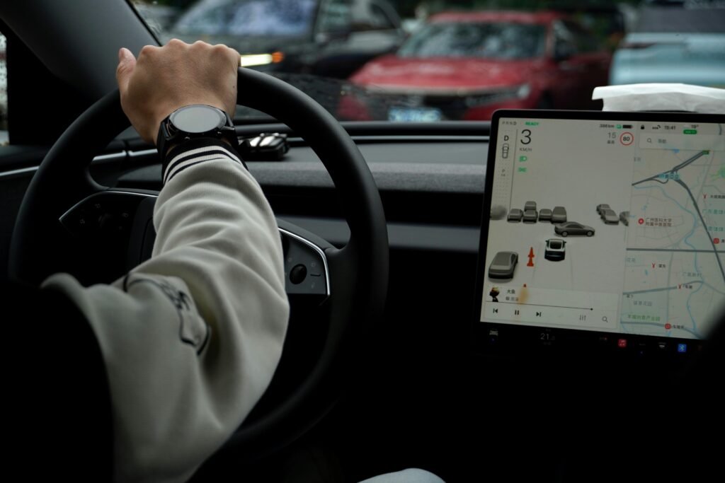 Fahrer steuert ein Auto mit großem digitalen Display im Armaturenbrett auf moderner Straße