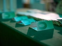 Mehrere Banknoten, die deutlich die Zahl Null abbilden, auf einer ebenen Fläche verteilt angeordnet