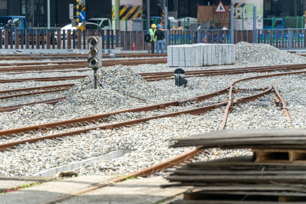 Bauarbeiten an Bahngleisen mit Schotterbett und sichtbaren Schienen auf einer offenen Baustelle