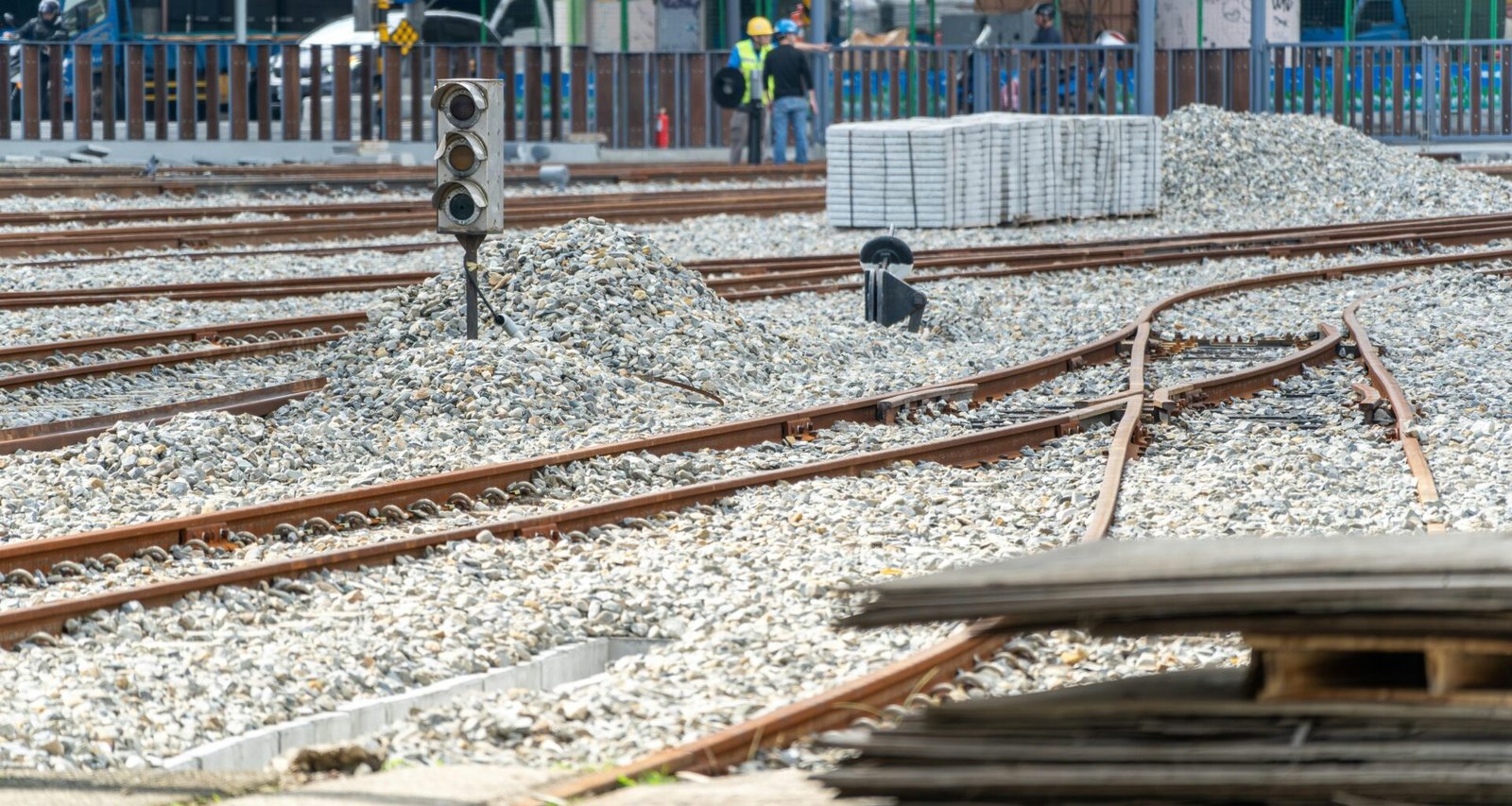 Bauarbeiten an Bahngleisen mit Schotterbett und sichtbaren Schienen auf einer offenen Baustelle
