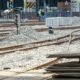 Bauarbeiten an Bahngleisen mit Schotterbett und sichtbaren Schienen auf einer offenen Baustelle