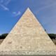 Beige Pyramide im Freien bei Tageslicht vor klarem Himmel, architektonisches Motiv für Design- und Architekturinhalte