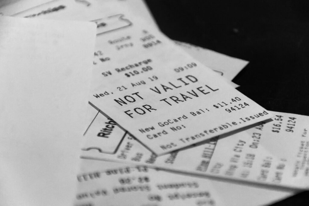 Ein Stapel Papierbelege, davon einer mit dem Vermerk 'Not valid for travel', fotografiert für Artikel über Quittungen.