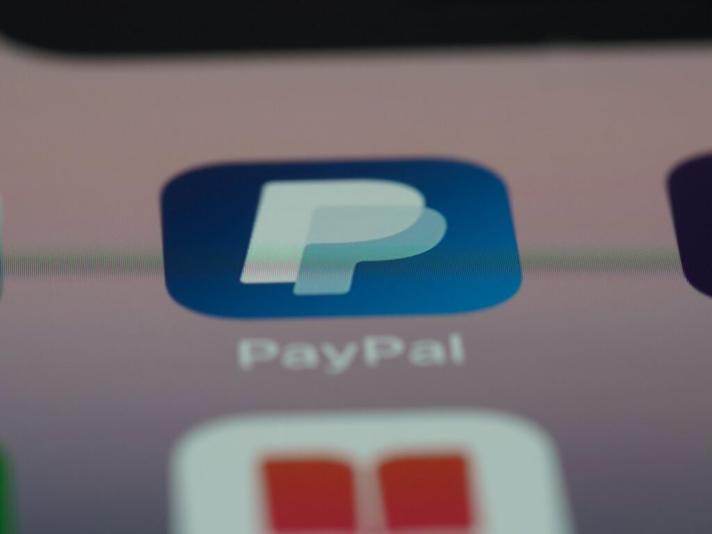 Blau-weißes Logo auf einem Computerbildschirm, aufgenommen in moderner Umgebung, Fokus auf digitales Design