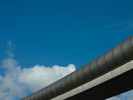Graues Betongebäude vor strahlend blauem Himmel mit klaren Linien und moderner Architektur