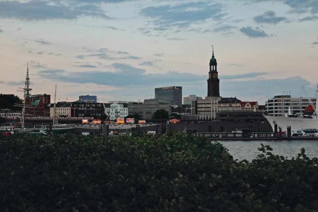 Blick über das Wasser auf eine Stadt mit Skyline und Ufer, fotografiert aus der Ferne bei Tageslicht