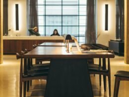 Braunes Holz-Esstisch-Set mit Stühlen in einem hellen, modernen Esszimmer, aufgenommen aus seitlicher Perspektive