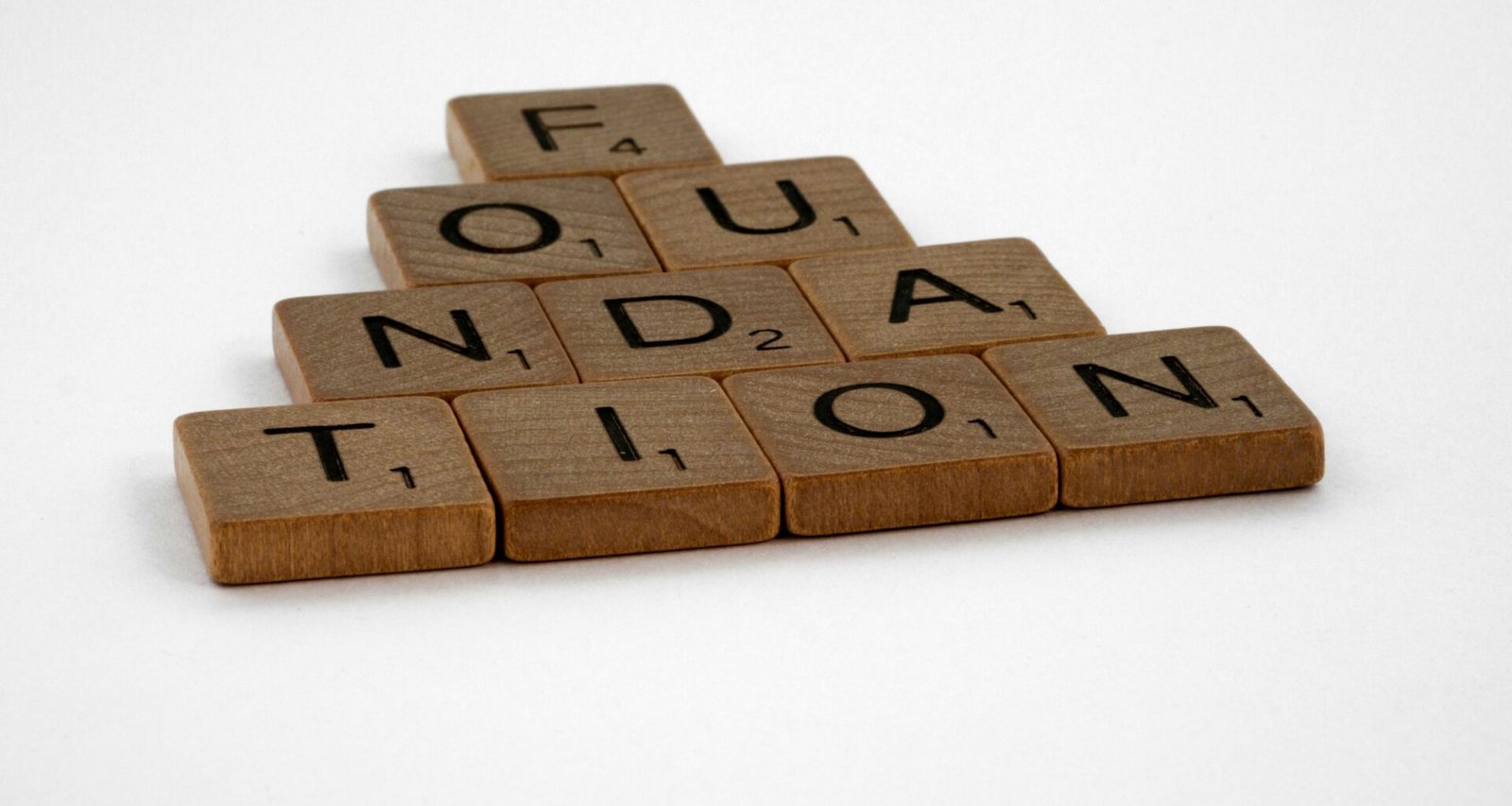 Mehrere braune Holzblöcke liegen ordentlich auf einer weißen Fläche nebeneinander angeordnet.