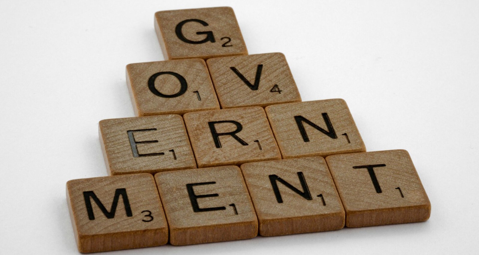 Braune, rechteckige Holzklötze auf einem weißen Untergrund, gleichmäßig angeordnet und von oben fotografiert.