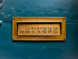 Braune Buchstabenbeschilderung auf einer türkisfarbenen Wand, fotografiert als modernes Designmotiv für Online-Marketing-Themen.