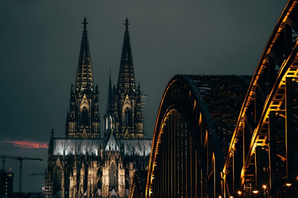 Braune Metallbrücke aus Stahl spannt sich über einen ruhigen Fluss, umgeben von natürlicher Landschaft, fotografiert von Omar Ramadan.