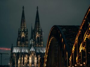 Braune Metallbrücke aus Stahl spannt sich über einen ruhigen Fluss, umgeben von natürlicher Landschaft, fotografiert von Omar Ramadan.