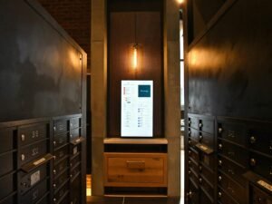 Brauner Holzschrank mit mehreren Stapeln weißem Druckerpapier in einem schlicht eingerichteten Büro