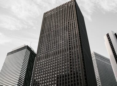 Braun-schwarzes Betongebäude unter weißen Wolken am Tag, mit moderner Fassadenstruktur in urbaner Umgebung